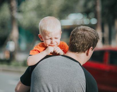 Tata niosący płaczące dziecko